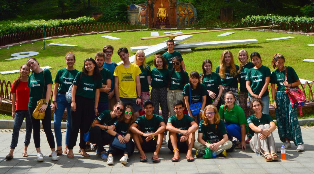 Young volunteers explore Cambodia during their team trip. A team of volunteers take a group photo outside Wat Phnom in Cambodia.